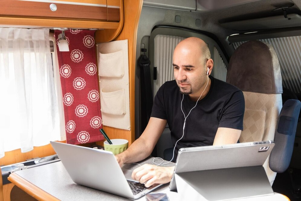 A person works remotely while traveling using a portable printer.